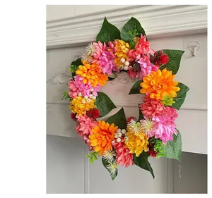 Close-up of vibrant autumn floral wreath with pink, orange, and yellow dahlias.