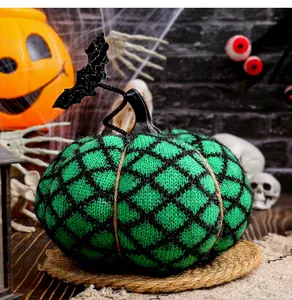 Detailansicht eines grünen Strickkürbisses mit Fledermausdeko für Halloween-Partys.