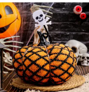 Detailansicht eines handgestrickten Halloween-Kürbis-Ornaments mit Filz-Totenkopf-Deko