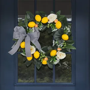 Artificial lemon wreath with black striped bow hanging on a dark blue front door.