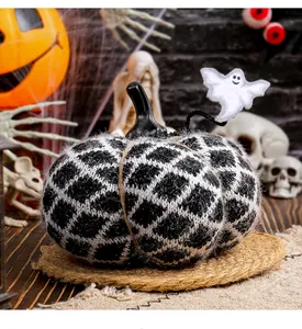 Nahaufnahme eines handgestrickten Halloween-Kürbis-Ornaments in Schwarz-Weiß mit Geist
