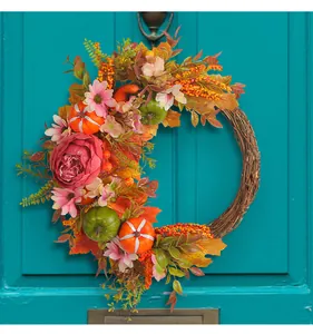 Close-up of harvest wreath featuring vibrant peonies, pumpkins, and autumn berries.