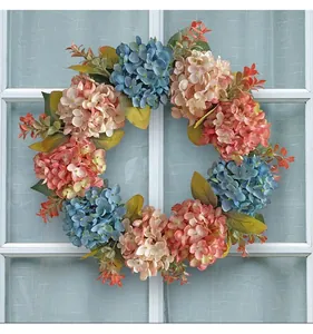 Detailed view of blue and pink artificial hydrangea wreath hanging on a white window frame.
