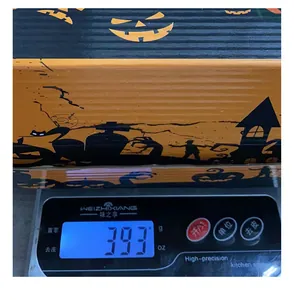 Detailed photo of a Halloween pumpkin lantern gift box on a digital scale weighing 393 grams