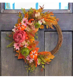 Detail view of harvest wreath with peonies, pumpkins, and autumn leaves on door