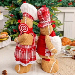 Schattige kerstpeperkoekmannetje chef-poppen met rode geruite hoeden en schort