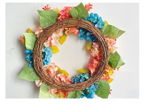 Detailed view of handmade blue and pink hydrangea floral wreath with vine base