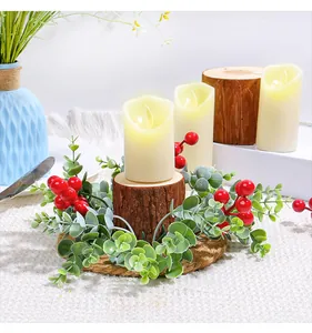 Detailansicht eines festlichen Weihnachtskerzenrings mit roten Beeren und Eukalyptusblättern