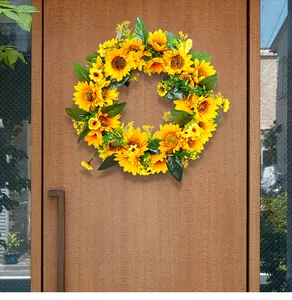 Couronne de tournesols artificiels sur une porte en bois pour décoration printanière