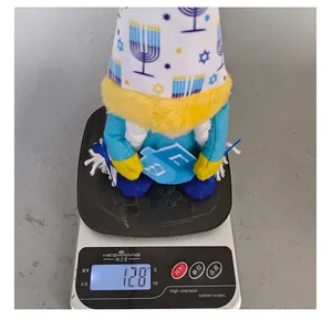 Handmade Hanukkah gnome plush doll showing a weight of 128 grams on a digital scale