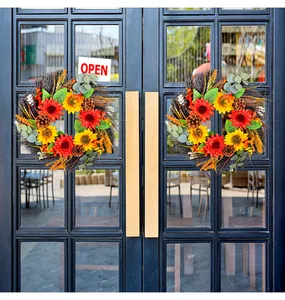 Vibrant artificial sunflower wreaths with pinecones decorating a modern glass door