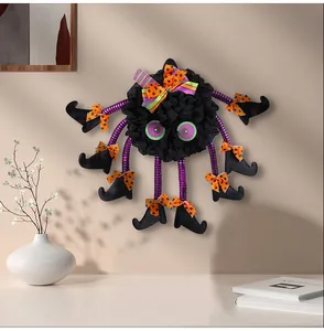 Detail view of a Halloween spider door hanging with purple striped legs and orange bows