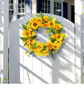 Couronne de tournesols artificiels sur un portail blanc, décoration printanière éclatante.
