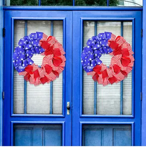 Due ghirlande patriottiche di nastri della bandiera americana su una porta blu decorativa.