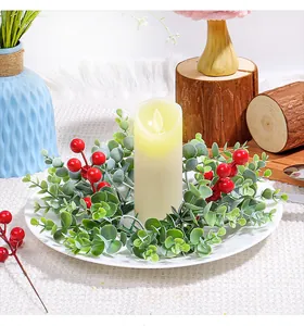 Detailansicht eines Weihnachtskerzenrings mit roten Beeren und Eukalyptusblättern