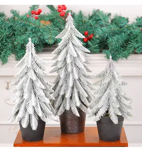 Detailed view of three flocked mini Christmas trees in pots for festive tabletop decor.