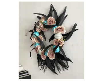 Detailed view of gothic Halloween wreath featuring black leaves, pink roses and blue pumpkins