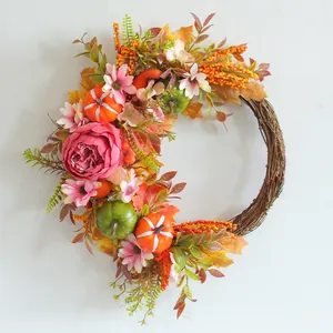 Autumn harvest wreath with pink peonies and decorative pumpkins for home door decor.