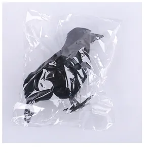 Detailed view of the Halloween black feathered crow prop inside clear plastic packaging
