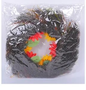 Decorative sunflower and red flower autumn wreath sealed in protective plastic bag packaging