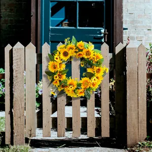 Couronne de tournesols artificiels pour décoration de porte sur une clôture rustique.