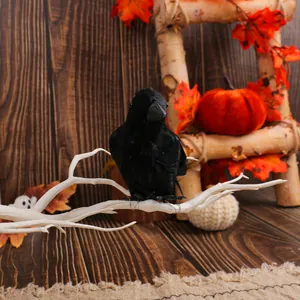 Realistic black feathered crow perched on a white branch for Halloween tabletop decoration