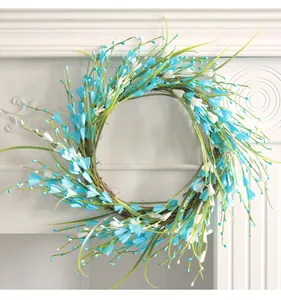 Detailed view of artificial berry wreath with blue and white flowers on a vine base