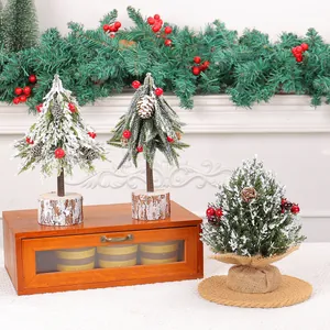 Set of three mini snow-covered desktop Christmas trees with red berries for holiday decor