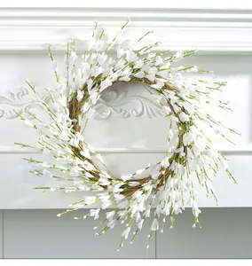 Detailed close-up view of an elegant white berry wreath displayed on a white fireplace