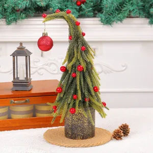 Miniature desktop Christmas tree with red berries and curved top for festive holiday decor