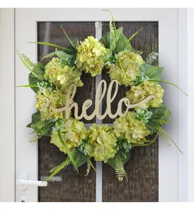 Detailed view of artificial green hydrangea wreath with wooden hello sign on door