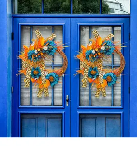 Couronne artificielle de tournesols bleus avec rubans léopard suspendue à une porte bleue