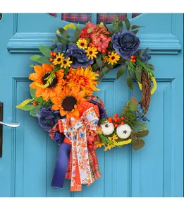 Close-up of vibrant artificial sunflower wreath with blue roses and pumpkin on blue door.