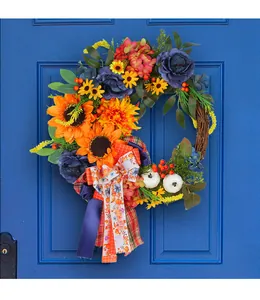 Vibrant artificial wreath with sunflowers and blue roses on a rustic rattan base.