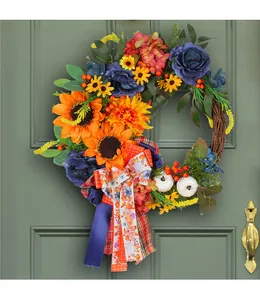 Detailed view of harvest wreath with blue roses and sunflowers on a green door