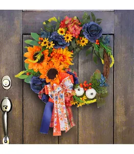 Detailed view of a handmade fall wreath with blue roses, sunflowers, and pumpkins