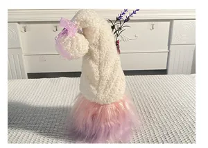 Detailed view of plush holiday gnome doll with white fuzzy hat and purple butterfly bow