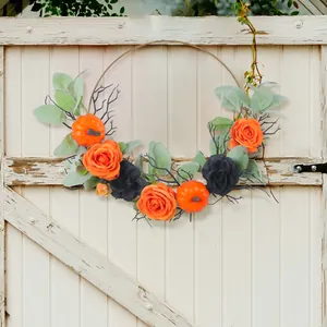 Elegante ghirlanda di Halloween con zucche arancioni e rose nere su anello di metallo.