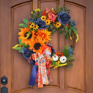 Autumn floral wreath with blue roses, sunflowers, and pumpkins hanging on a wooden door