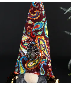 Detailansicht eines Halloween-Zwerghuts mit Paisley-Mustern und einem metallischen Spinnenanhänger