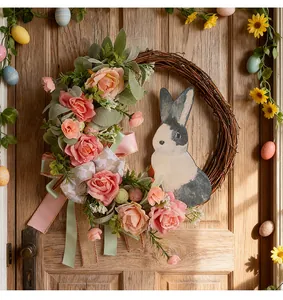 Detailansicht eines Osterhasen-Kranzes mit rosa Rosen und bunten Eiern an Holztür.