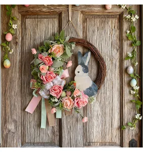 Detailansicht des künstlichen Osterhasen-Kranzes mit Rosen und Bändern an der Tür