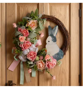 Detailansicht eines Osterkranzes mit rosa Rosen und hölzernem Hasen an einer Tür