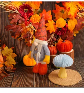 Vista detallada de un gnomo de otoño con calabazas y hojas secas decorativas