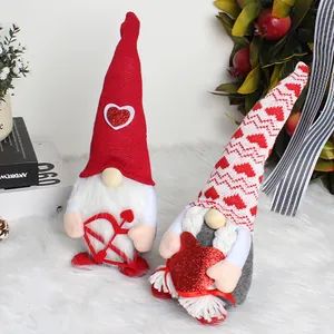 Pärchen Valentinstag Wichtel ohne Gesicht mit roten Herzen auf weißem flauschigem Grund.