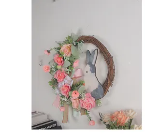 Detailansicht eines Osterkranzes mit rosa Rosen, grünen Blättern und Hasenausschnitt