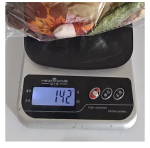 Gewichtsmessung der Erntedankfest-Puppe, die 142 Gramm auf einer digitalen Waage anzeigt.