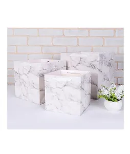 Detail showing three square marble pattern paper gift bags with die-cut handles