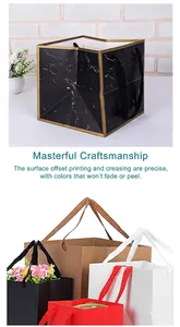 Detail of various square paper gift bags with marble pattern and colorful ribbon handles