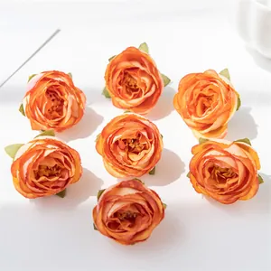 Detailansicht von sieben vintage orangefarbenen Seidenrosenköpfen für DIY-Handwerk.